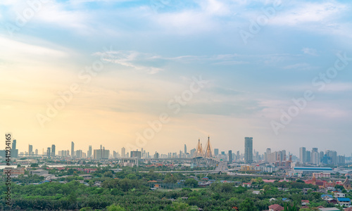 Cityscape of modern building with highway and community in Bangkok. Car driving on elevated bridge. Skyscraper building. Green trees in city. Oxygen for urban life. Eco-friendly city. Urban skyline.