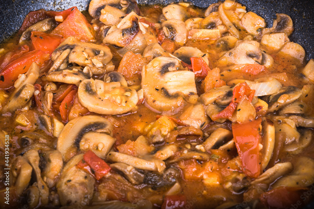 Healthy vegetarian dish with vegetable protein - mushrooms in tomato and onion sauce, close-up