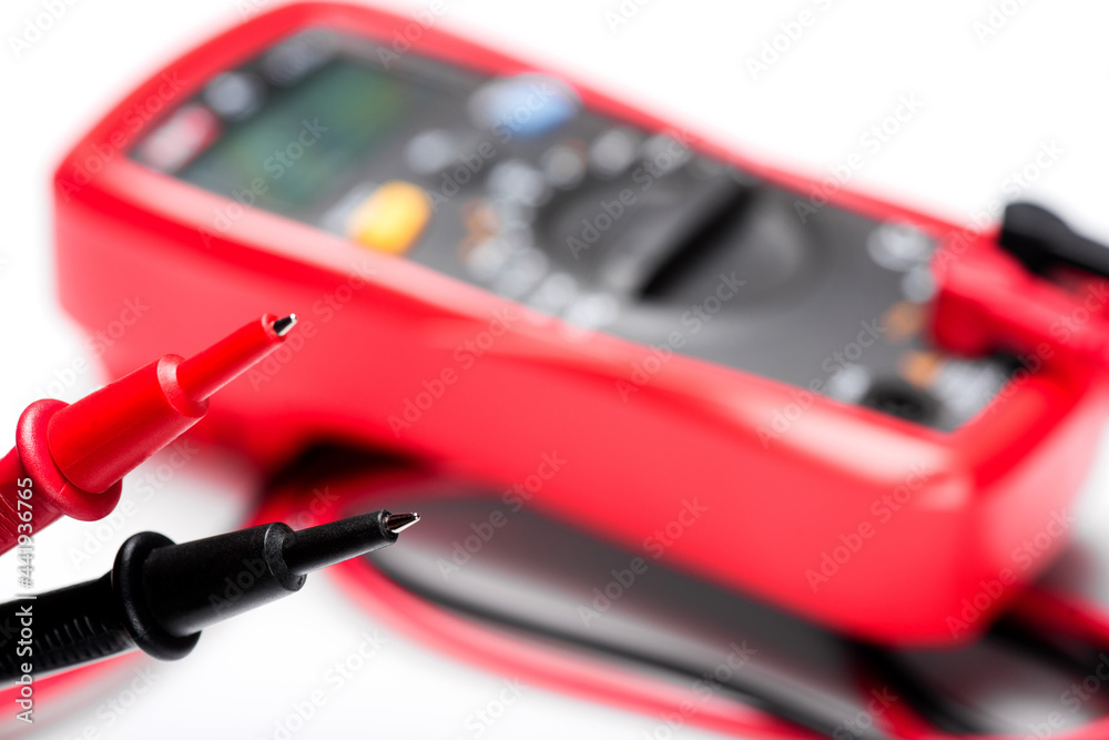 Electronic digital multimeter isolated on white with probes. Digital multimeter with red and black leads. Electronic multimeter isolated on white background close up Electronic digital multimeter isolated on white with probes. Digital multimeter with red and black leads. Electronic multimeter isolated on white background close up