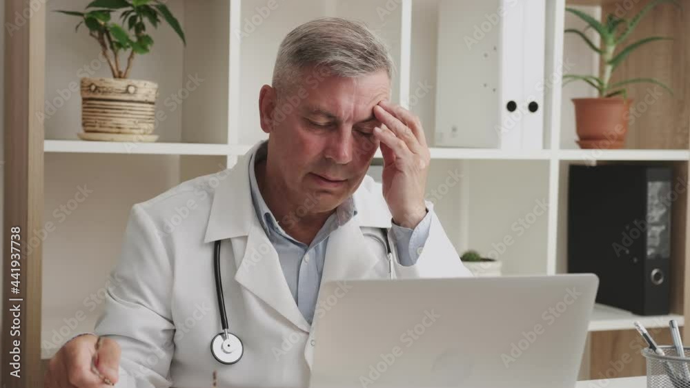 overworked doctor during hard office work, senior man in front of monitor overworked doctor during hard office work, senior man in front of monitor
