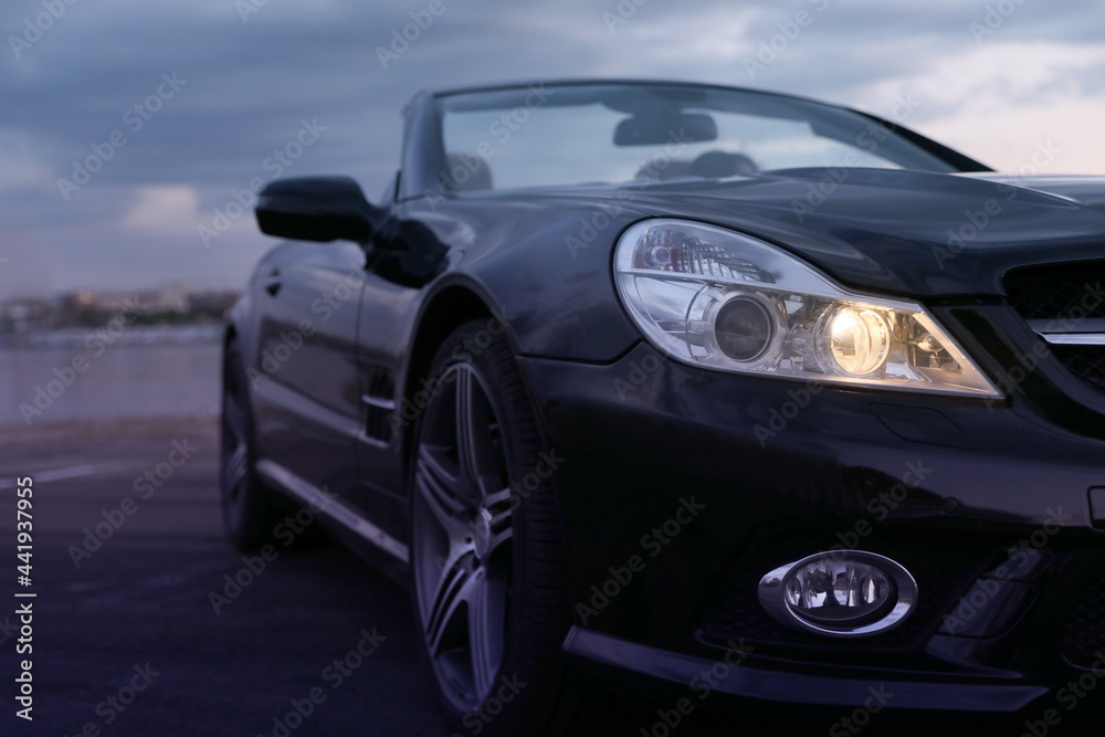 Fototapeta premium Luxury black convertible car outdoors in evening, closeup