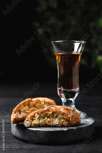 Tasty cantucci and glass of liqueur on wooden table. Traditional Italian almond biscuits © New Africa