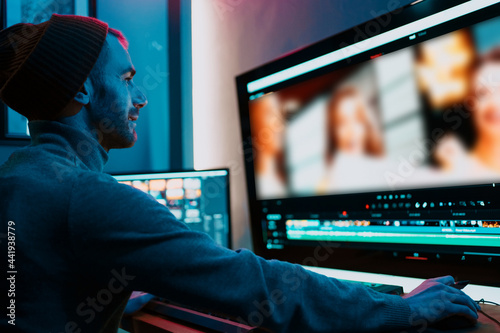Valokuva Attractive Male Video Editor Works with Footage or Video on His Personal Computer, he Works in Creative Office Studio or home