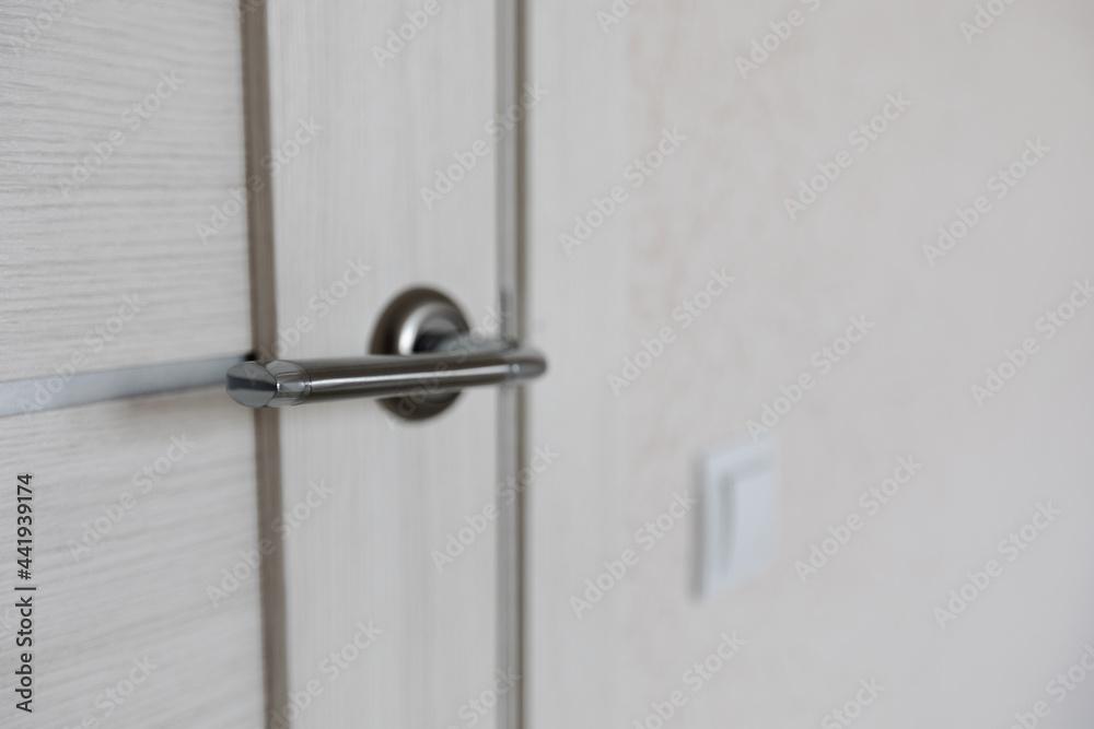 New interior doors close-up. the handle on the door is silver. the concept of renovation and design of the apartment New interior doors close-up. the handle on the door is silver. the concept of renovation and design of the apartment