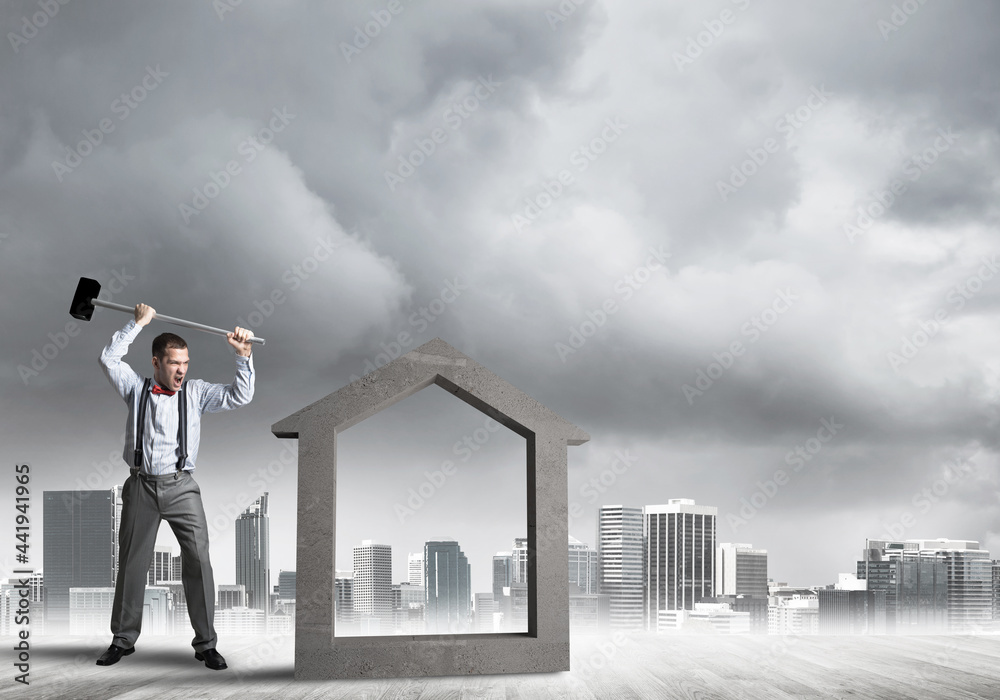 Manager man crashing stone home as symbol for real estate insurance