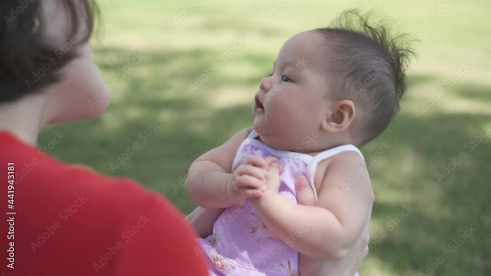 asian woman mother playing with happy baby infant in garden on sunny day under tree on picnic vacation. smile baby happy fun family time. asian woman mother playing with happy baby infant in garden on sunny day under tree on picnic vacation. smile baby happy fun family time.