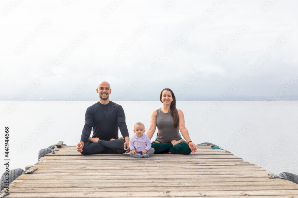Smiling yoga family in meditation pose