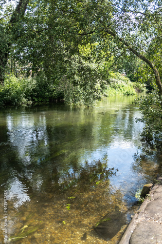 A view down the River Test in the town of Romsey, Hampshire. Captured from the river bank on a bright and sunny day © yackers1