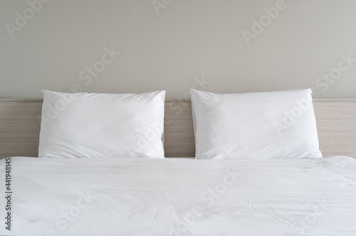 empty two or dual pillow on nobody clean white bed and wooden headboard or brown wall background in bedroom at home and feel married or marry for sleep relax at night or morning wake up comfortable