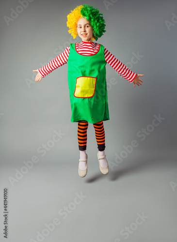 Fototapeta The little girl jumps in a clown uniform