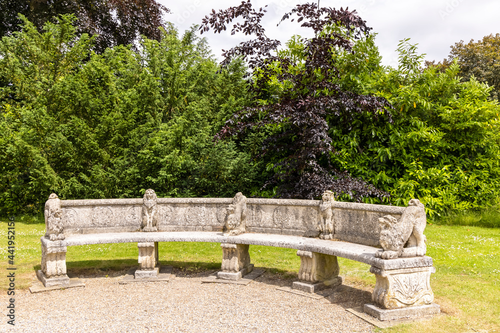 Vintage carved stone garden bench in a park.