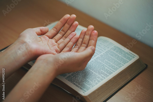Fotografia Woman hands praying with an open bible in her room