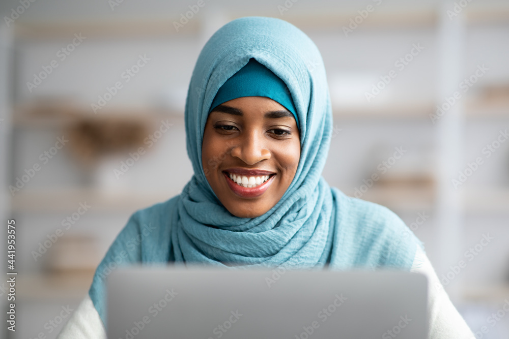 Closeup Shot Of Black Muslim Lady In Blue Hijab Using Laptop Closeup Shot Of Black Muslim Lady In Blue Hijab Using Laptop