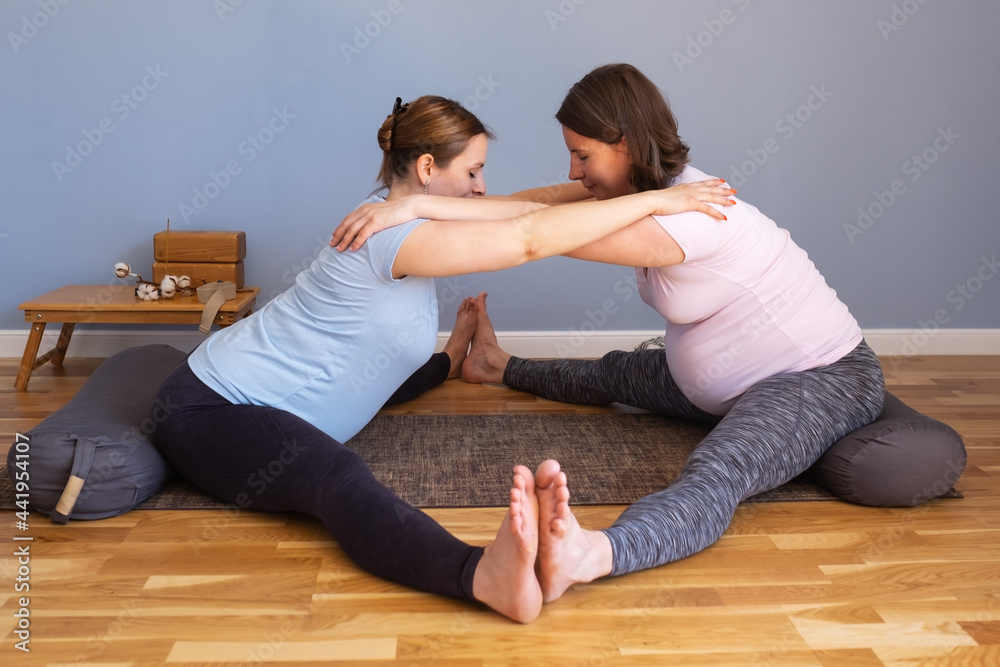 Pregnant women working out idoing Seated straddle posture, Upavishtha Konasana Pregnant women working out idoing Seated straddle posture, Upavishtha Konasana