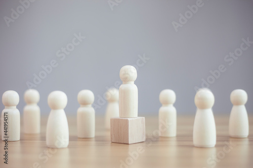  Wooden person model among people on black background, Leadership concept.