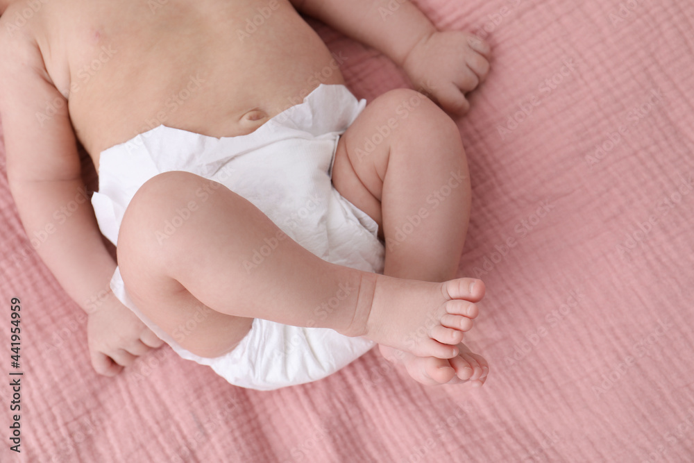 Little baby in diaper on bed, closeup Little baby in diaper on bed, closeup