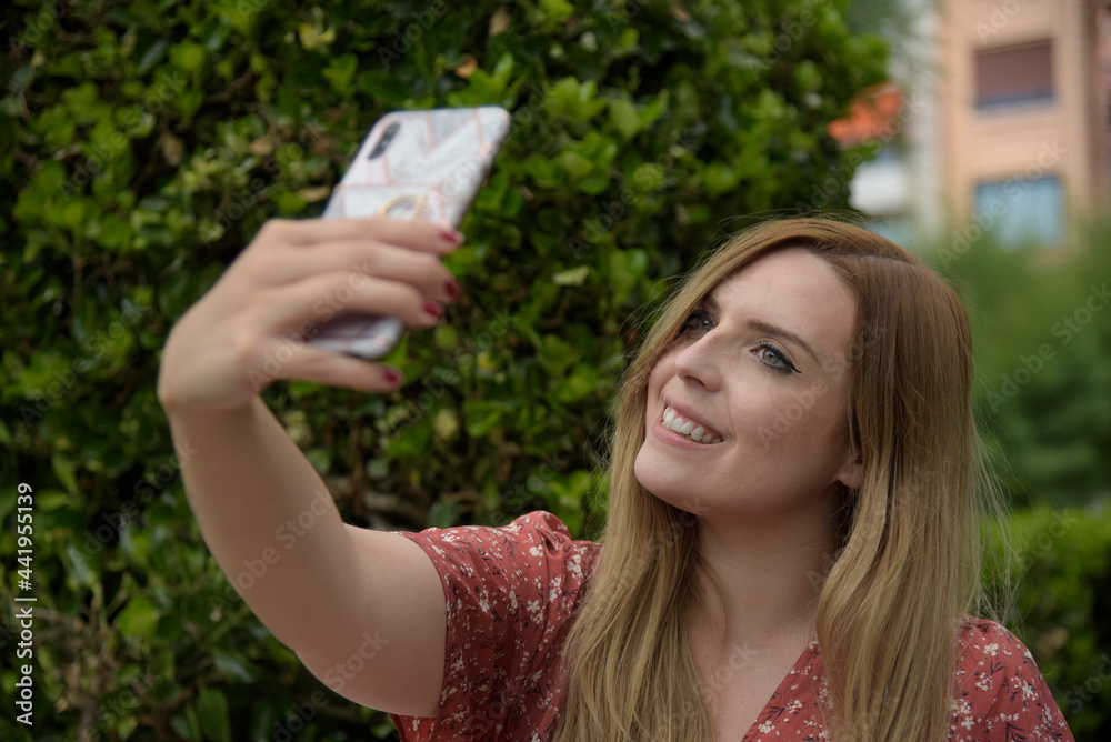 retrato de mujer rubia sonriendo y mirando el teléfono móvil retrato de mujer rubia sonriendo y mirando el teléfono móvil