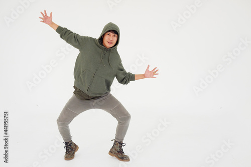 Smiling Asian young professional dancer man is break dancing by one leg and arm isolataed on white background in studio. Education and sport for hobbies concept. photo