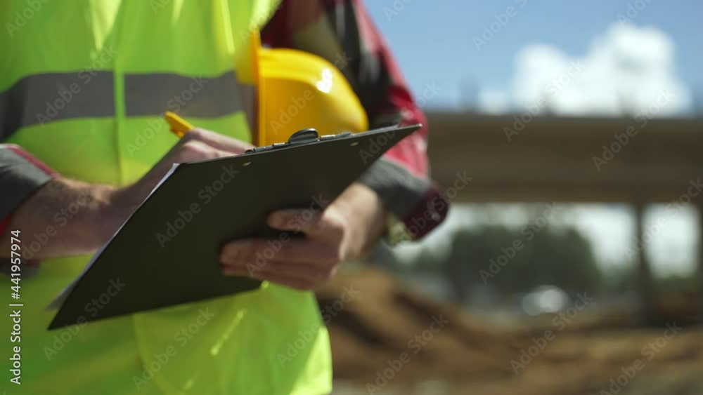 Builder with hard hat inspects construction site. Close-up. Builder with hard hat inspects construction site. Close-up.