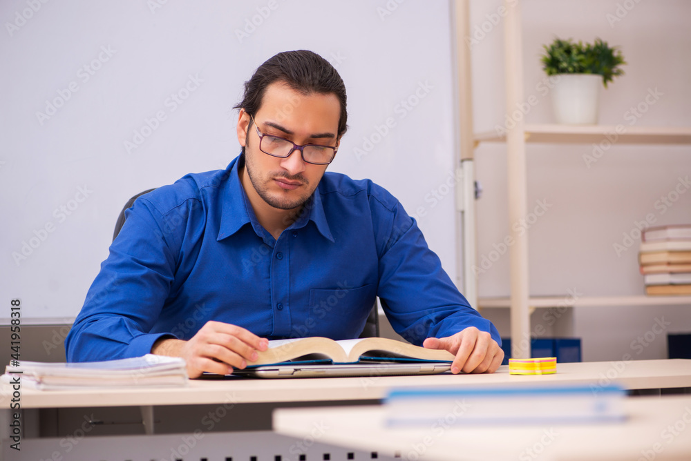 Young male teacher in front of whiteboard Young male teacher in front of whiteboard