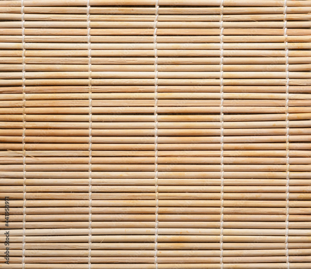 Texture of bamboo knitted with cotton thread. Cooking utensils for making sushi rolls. Beige bamboo background Texture of bamboo knitted with cotton thread. Cooking utensils for making sushi rolls. Beige bamboo background