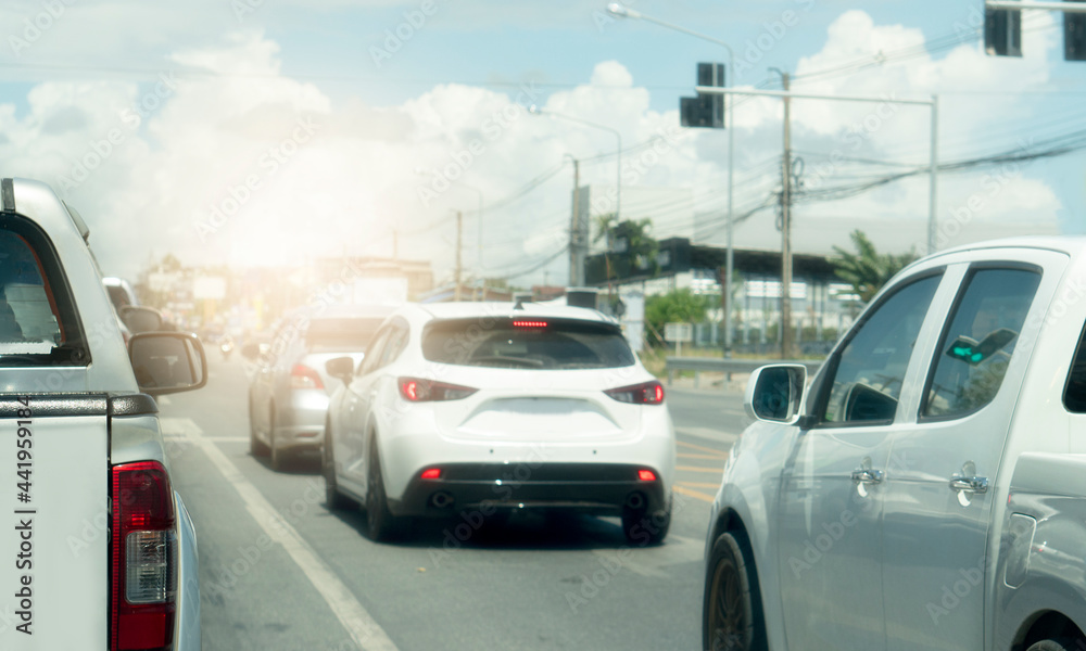 Cars on the road heading towards the goal of the trip. Every car stop by traffic light control at front junction in the city. under blue sky. Cars on the road heading towards the goal of the trip. Every car stop by traffic light control at front junction in the city. under blue sky.