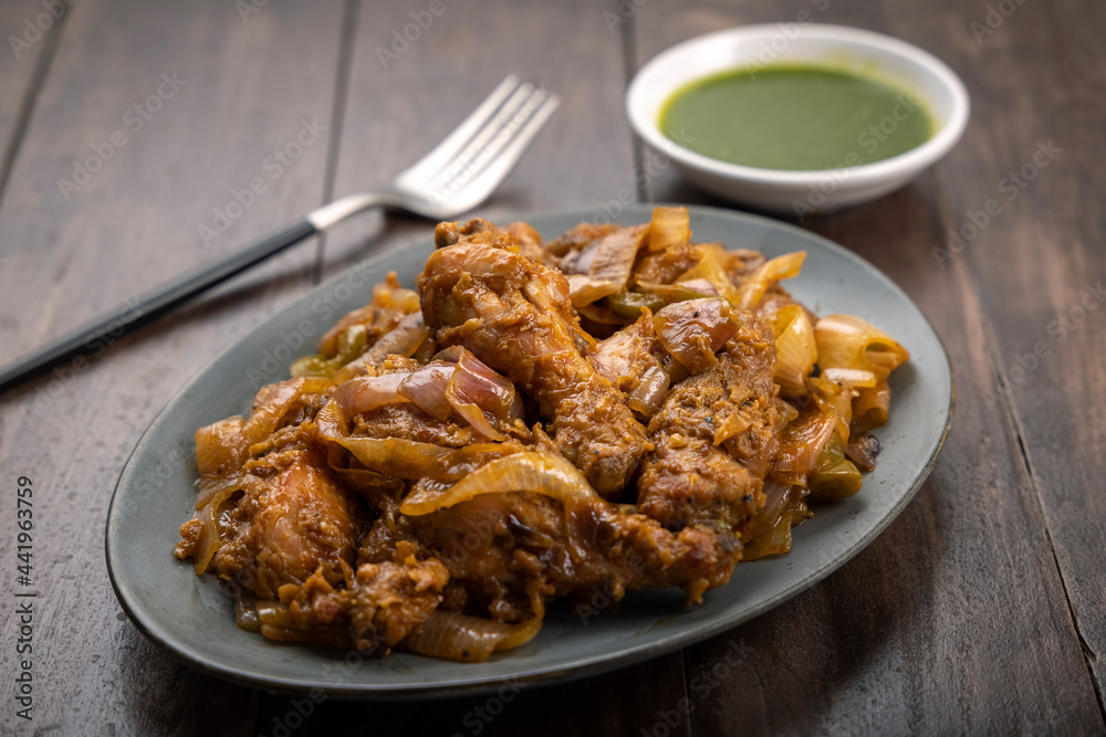 Chilli chicken is a popular Indo-Chinese dish, served on a plate on wooden background
Chilli chicken is a popular Indo-Chinese dish, served on a plate on wooden background