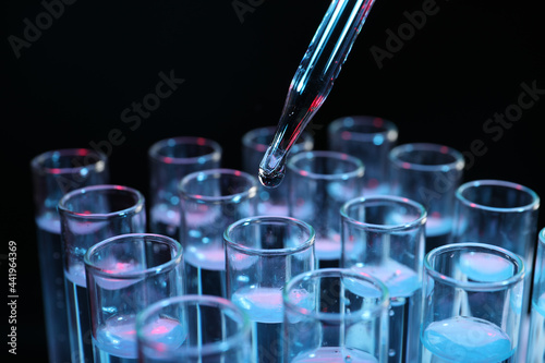 Dripping reagent into test tube on black background, closeup. Laboratory analysis