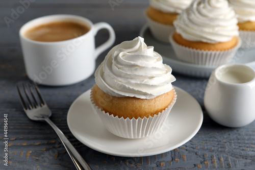 Delicious cupcake with cream on grey wooden table, closeup