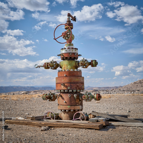 unused head of oil well with numerous valves in a desert landscape of central Utah photo
