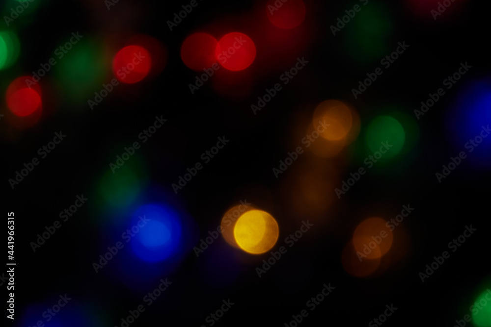 Defocused large bokeh multicolored lights on black background. Blurred abstract blue, green, red, orange spots. Blur bokeh spots wallpaper for Christmas, holiday background. Defocused large bokeh multicolored lights on black background. Blurred abstract blue, green, red, orange spots. Blur bokeh spots wallpaper for Christmas, holiday background.