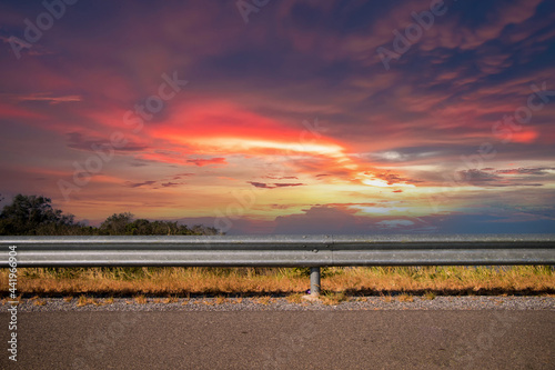 Ocean side highway and Gard rail, behind is beautiful mountain view and blue sky. Road side view mountain and sea background. Side road with mountain and twilight sky view © kanpisut