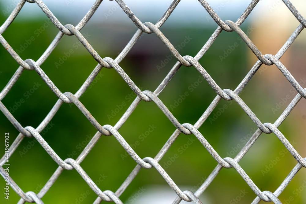 Fototapeta premium A close up picture of a rusty wire fence with colorful background