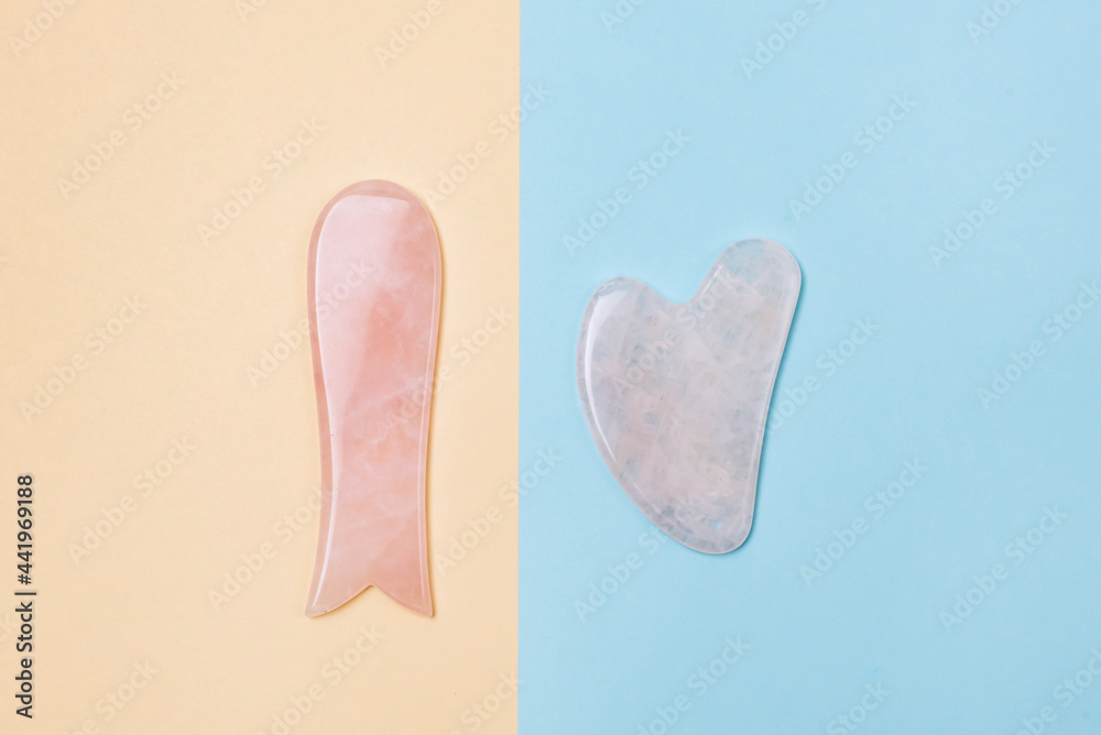 Cosmetic Massage Pink Jade Gua Sha Scrapers for Facial and Body Skin Care Spa and Beauty Concept Yellow and Blue Color Block Background Minimal Cosmetic Massage Pink Jade Gua Sha Scrapers for Facial and Body Skin Care Spa and Beauty Concept Yellow and Blue Color Block Background Minimal