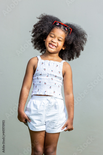 child woman afro hairstyle afro wearing red glasses showing emotionc and poses Isolated on gray background, childhood and emotion concept.