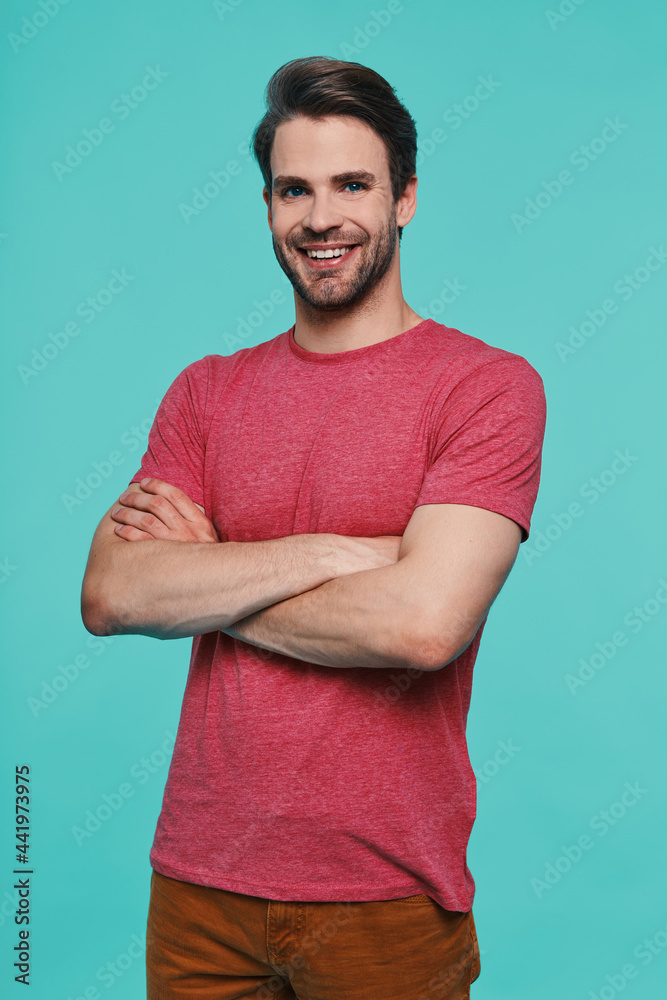 Handsome young man in casual clothing looking at camera and smiling Handsome young man in casual clothing looking at camera and smiling