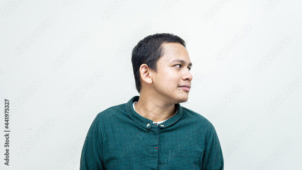 Smiling face expression of young Asian Malay man looking at empty space for indicated advertisement. Smiling face expression of young Asian Malay man looking at empty space for indicated advertisement.