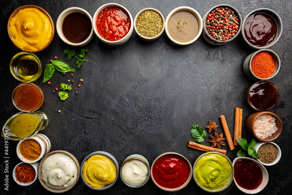 Set of different bowls of various dip sauces, on dark background, top view Set of different bowls of various dip sauces, on dark background, top view