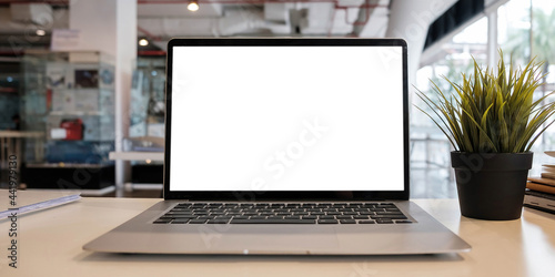 Blank screen Laptop computer and poster workspace background in modern office