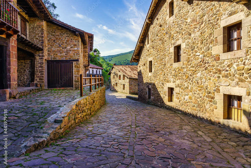 Stone houses and narrow alley in mountain village in northern Spain. Barcena Mayor.