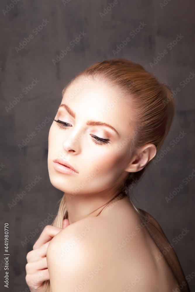 Beauty portrait of young model woman with clean perfect skin, make-up, red hair, grey background Beauty portrait of young model woman with clean perfect skin, make-up, red hair, grey background