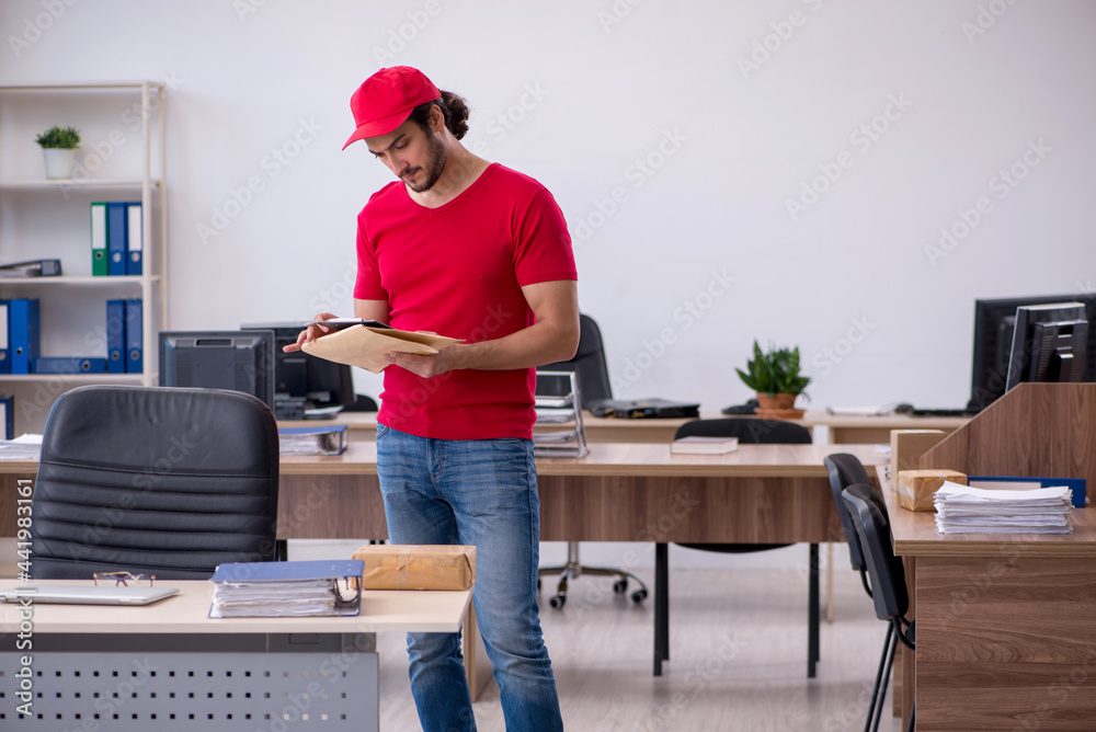 Young male courier delivering post to the office