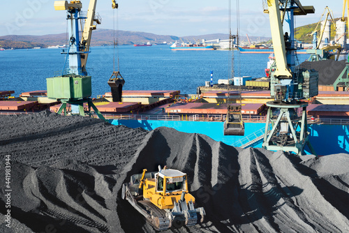 Coal is loaded into the holds of a dry cargo ship in the seaport 24 hours a day.