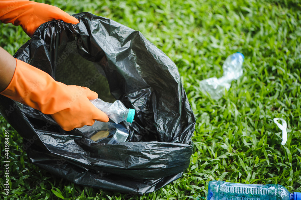 Man hand picking up garbage plastic gathering plastic bottle garbage at the park. World environment day.Environment concept.. Man hand picking up garbage plastic gathering plastic bottle garbage at the park. World environment day.Environment concept..