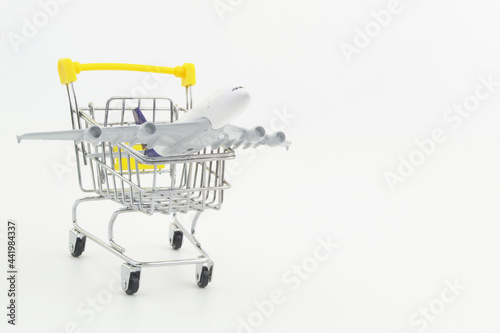 Airplane model in shopping cart with copy space. Buy air tickets and travel tour concept.  © Valerii Evlakhov