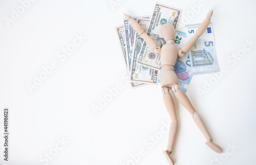 Wooden man sitting on a stack of money. Business concept.