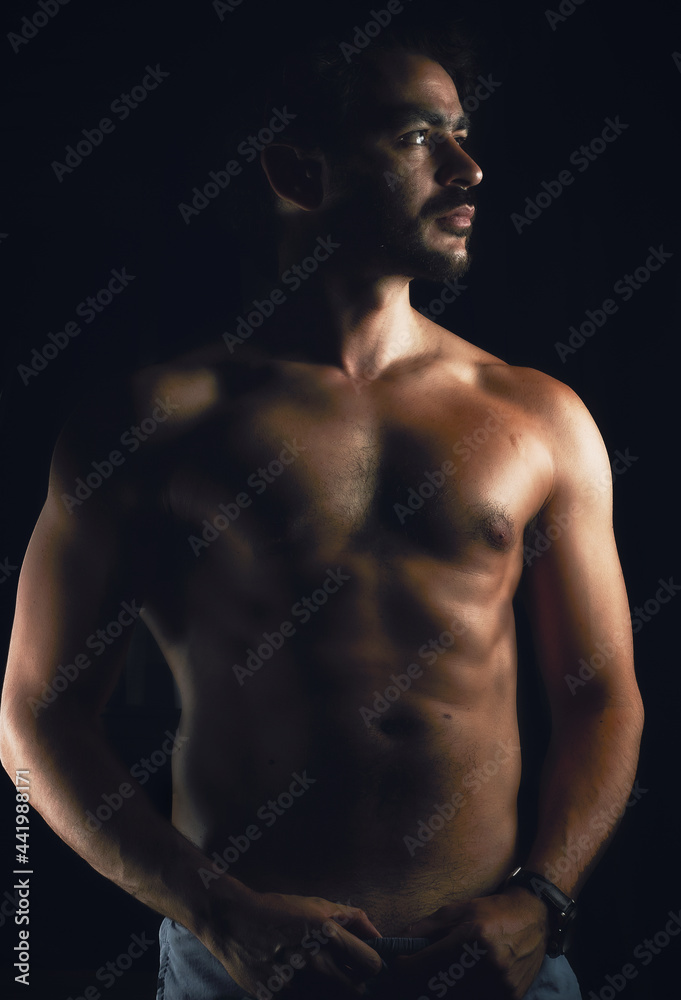 Fototapeta premium Man posing naked torso with black background