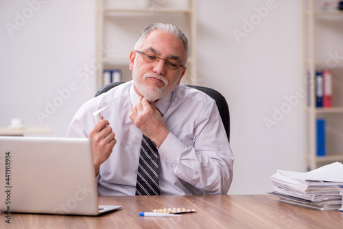 Aged male employee suffering at workplace