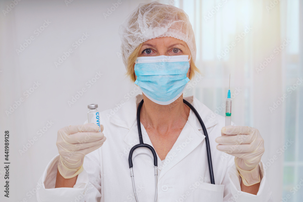 Doctor with mask and syringe is ready to administer the vaccine against covid-19 Doctor with mask and syringe is ready to administer the vaccine against covid-19