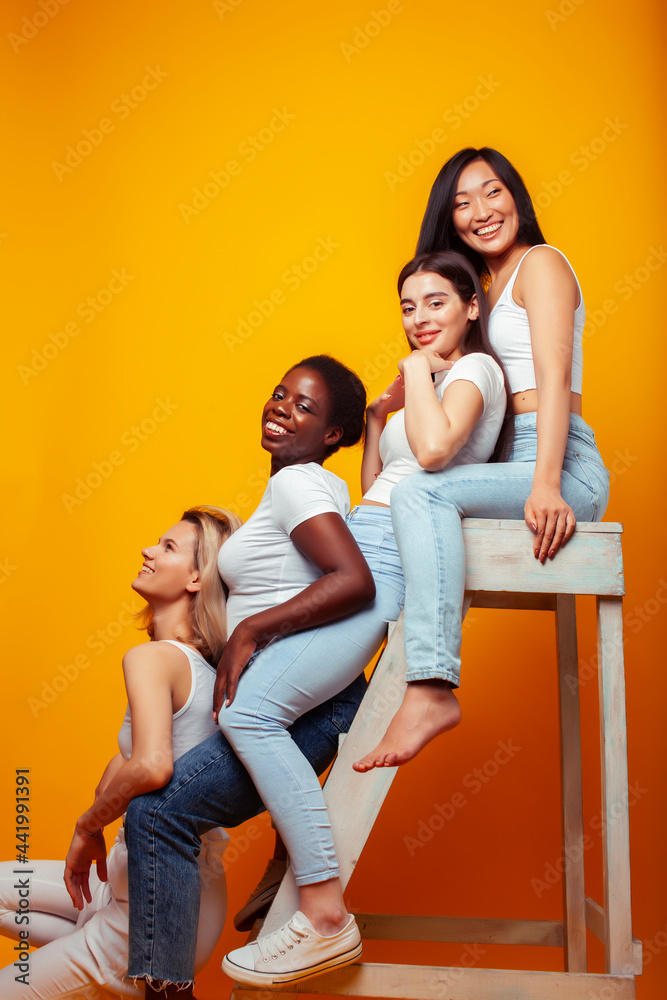 diverse multi nation girls group, teenage friends company cheerful having fun, happy smiling, cute posing on yellow background, lifestyle people concept, african-american, asian and caucasian diverse multi nation girls group, teenage friends company cheerful having fun, happy smiling, cute posing on yellow background, lifestyle people concept, african-american, asian and caucasian